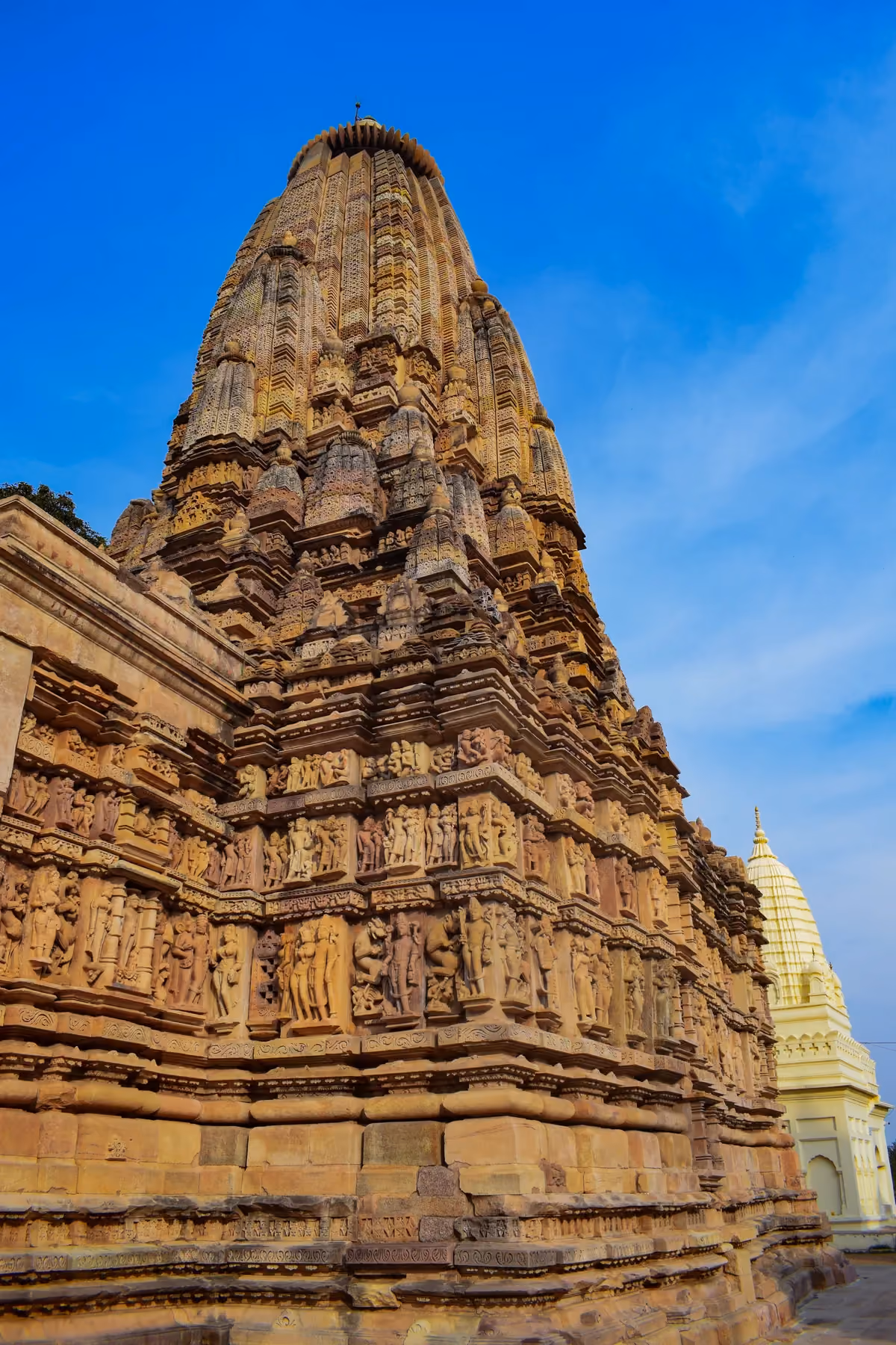 The sandstone tower and carved walls of the Parshvanatha Jain temple in the eastern group at Khajuraho